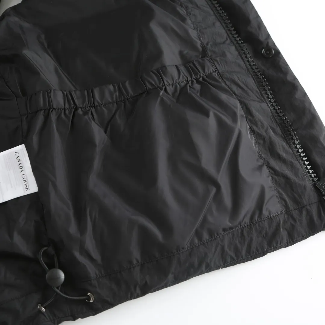 P740 Big Goose Logo Hooded Down Vest Fabric selection: The use of high-quality protective nylon fabric not only enhances the wear resistance of the surface, but also takes into account wind resistance, ensuring excellent performance in various harsh weather conditions.  90 national standard high-quality white duck down: selected high-loft down, weighing 170g, light and warm, with excellent temperature locking performance and good resilience.  Three-dimensional quilting process: Precision thread reinforcement to prevent velvet drilling and ensure that the fluffy and resilient elasticity lasts as new.  Details: Use polyester as the base for woven webbing, and use high-precision computer embroidery to decorate the brand letters on the webbing. The edges of the pattern are clear, the stitches are fine and even, and multiple layers of embroidery threads are stacked to enhance the three-dimensional effect. Accessories: One-to-one customized logo One-to-one customized zipper pendant One-to-one customized hem elastic buckle One-to-one customized snap button SIZE: S M L XL